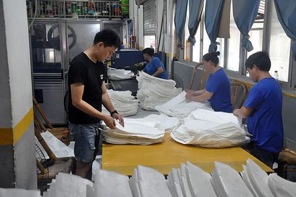 Workers are inspecting the bags for quality